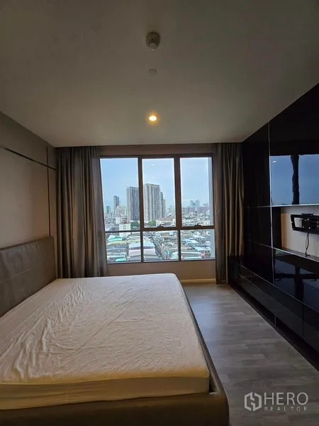 Condominium for rent - Bedroom with bed frame and panoramic city view through full-height windows.