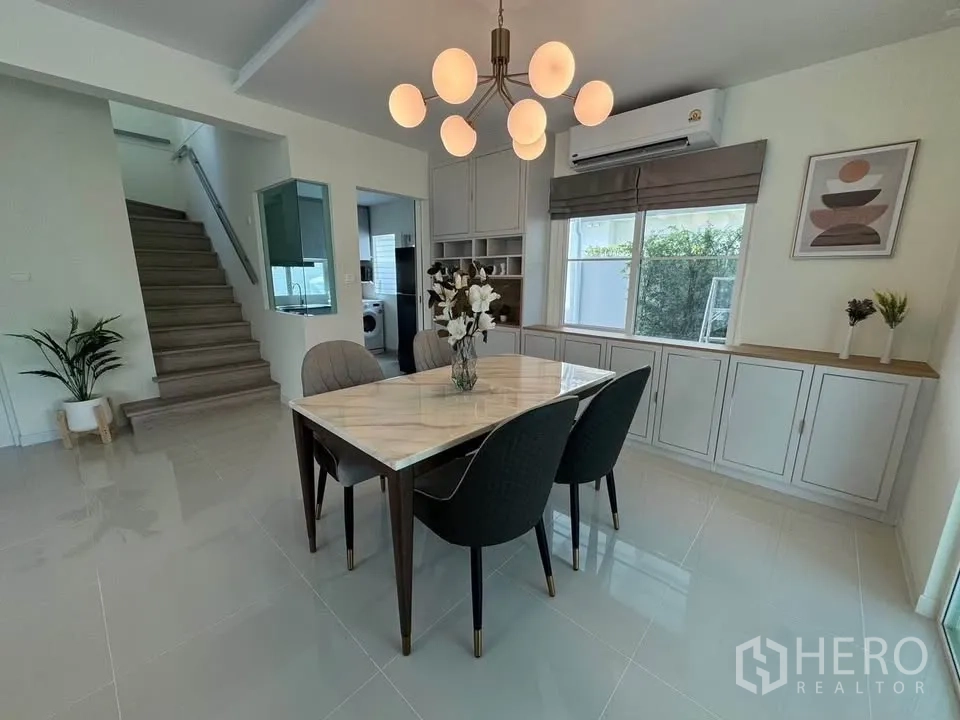 Detached House for rent in Bang Phli, Samut Prakan - Dining area with marble-top table, modern chandelier, and built-in cabinetry.