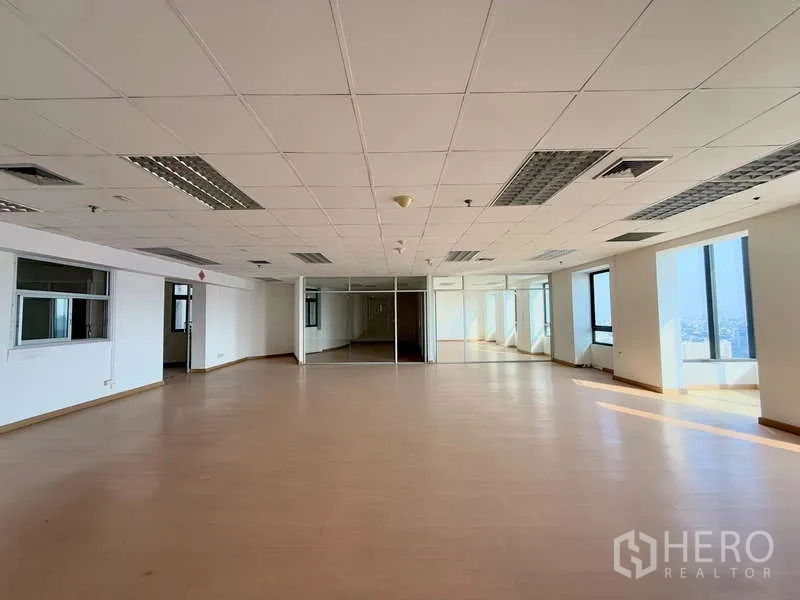 Office Space for rent in Chatuchak, Bangkok - Spacious open-plan office with large windows, wood-look flooring and drop ceiling lights, offering city views in Chatuchak.