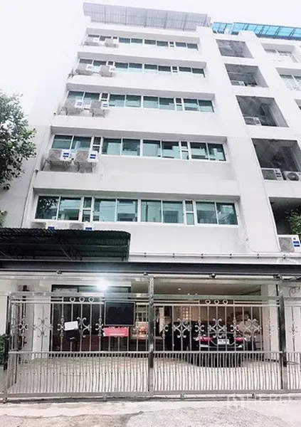 Home Office for rent in Phaya Thai, Bangkok - Mid-rise building façade with secure metal gate and ground-floor parking in Phaya Thai.