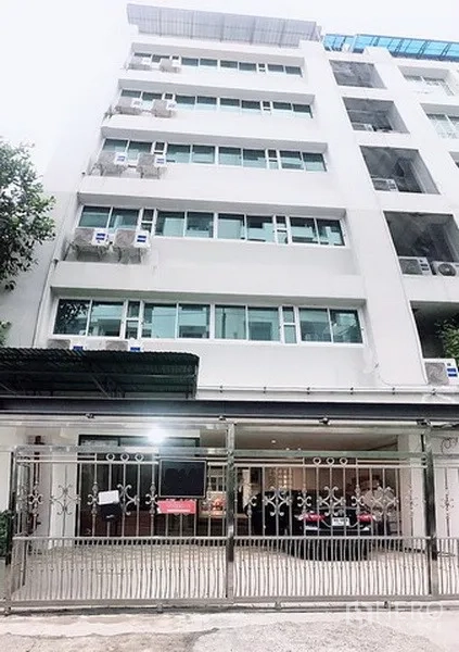 Home Office for rent in Phaya Thai, Bangkok - Mid-rise building façade with secure metal gate and ground-floor parking in Phaya Thai.