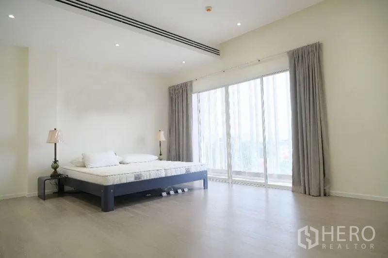 带办公室的家 出租或出售在Prawet, Bangkok - 大卧室，推拉落地门通阳台，木地板与窗帘。