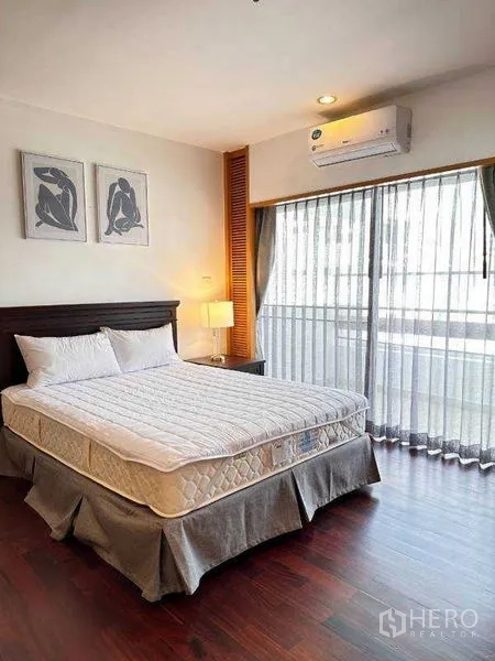 Apartment for rent - Guest bedroom with bed, nightstand and sliding balcony doors with sheer curtains.