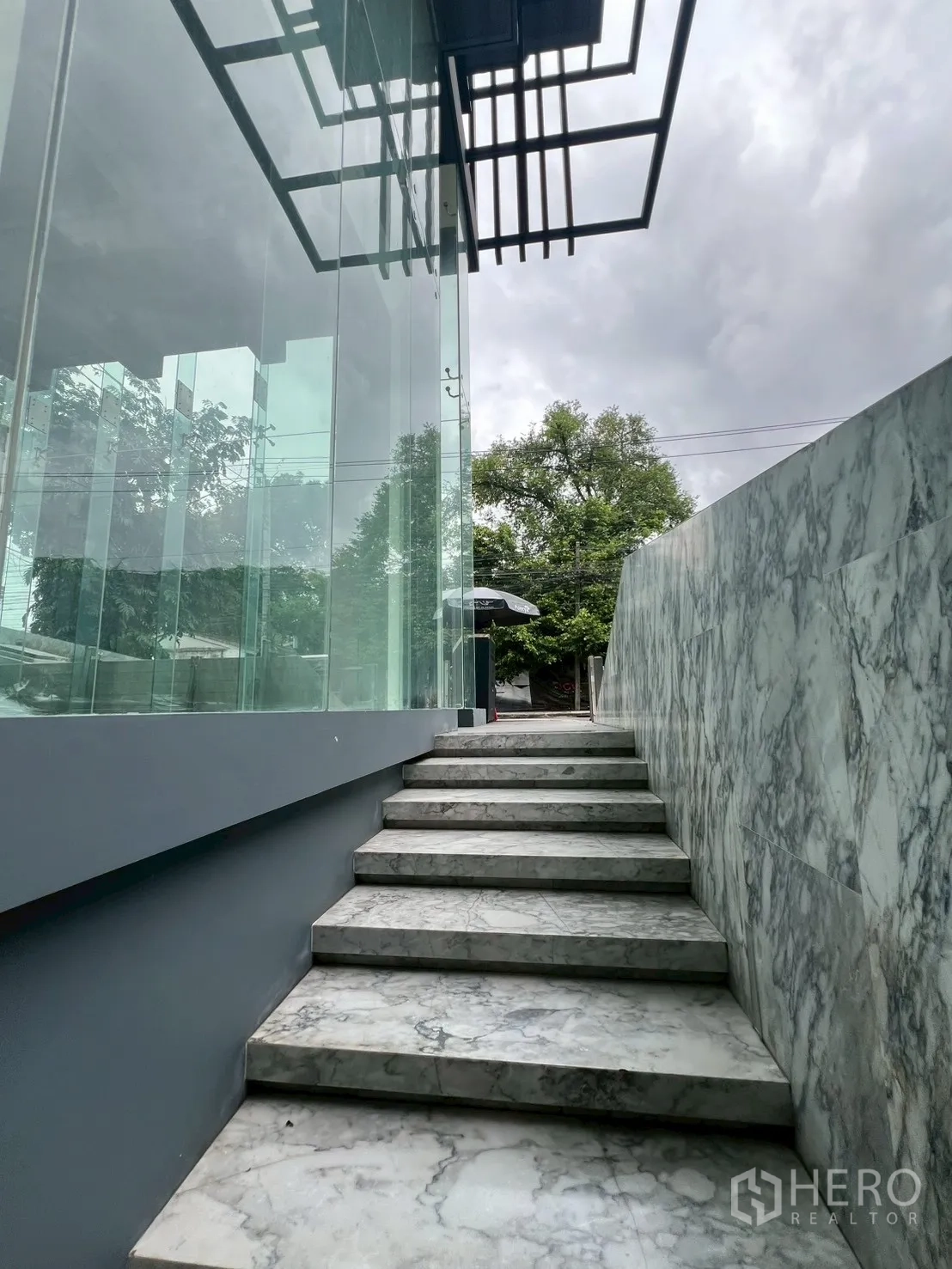 Retail Space for rent - Exterior marble staircase along the glass facade leading to the shop.
