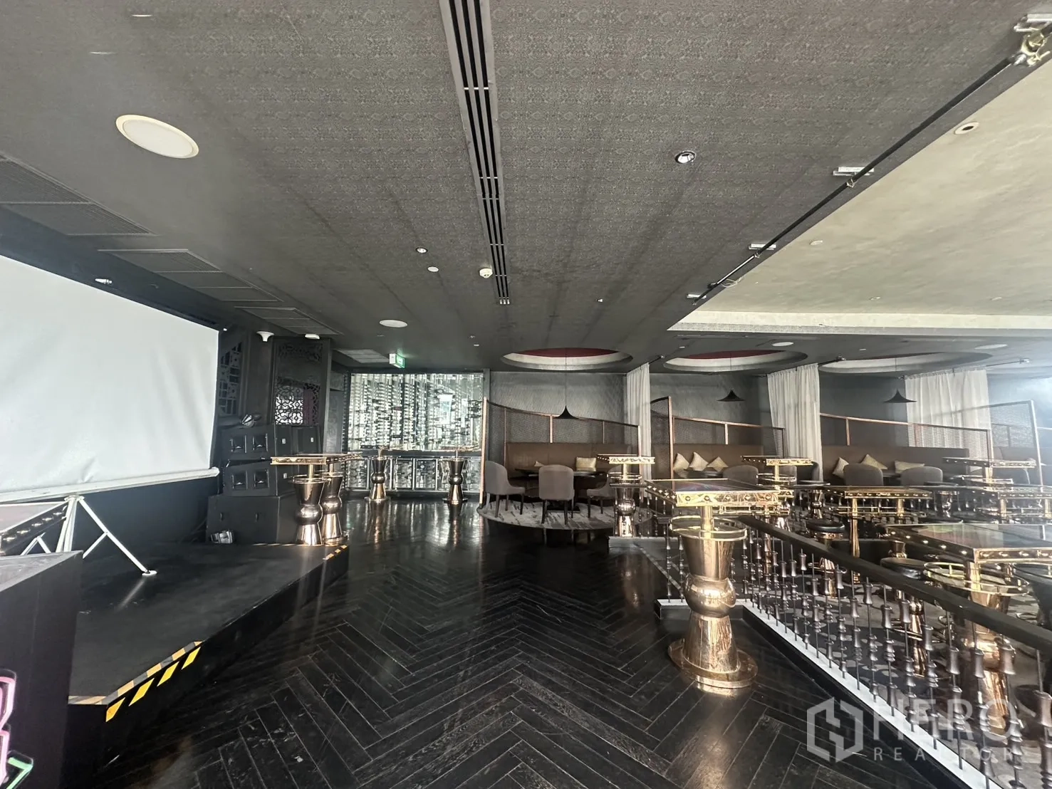 Retail Space for rent in Khlong Toei, Bangkok - Stage with projector screen facing lounge seating and cocktail tables.