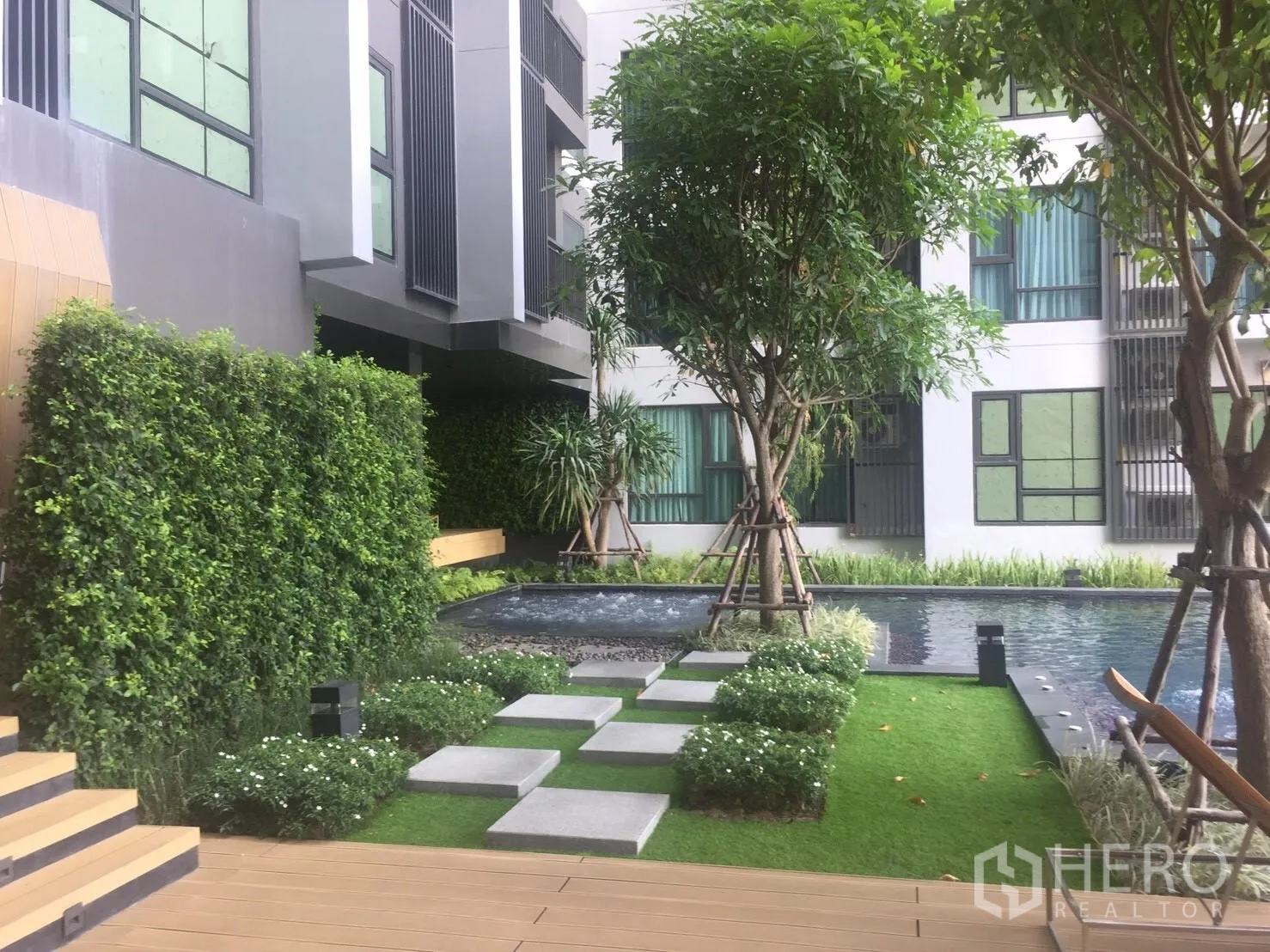 Condominium for rent in Khlong Toei, Bangkok - Landscaped courtyard featuring stepping stones, a vertical garden wall and a reflecting pool at the condominium.