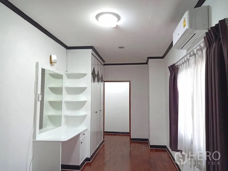 Condominium for rent in Watthana, Bangkok - Bright hallway-bedroom space with built-in vanity, shelves, wardrobe, and wood flooring.
