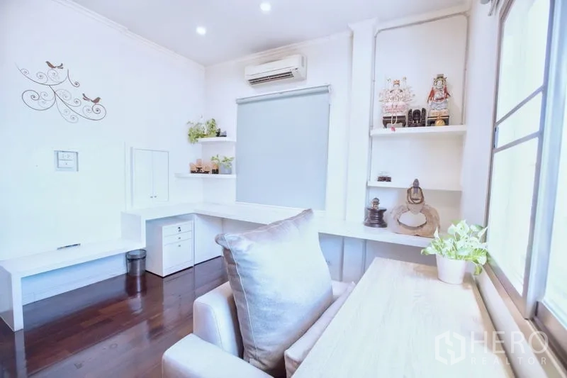 Detached House for sale in Lat Krabang, Bangkok - Light-filled home office with built-in shelves, desk, air conditioning and decor.