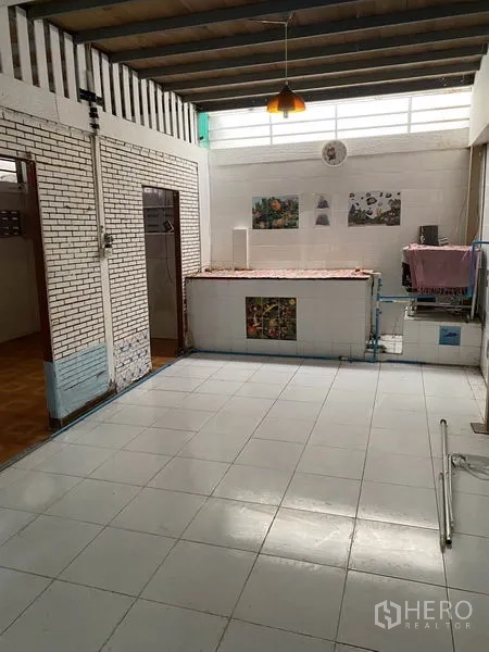 Townhouse for rent in Lat Phrao, Bangkok - Covered utility patio with white floor tiles and high clerestory windows.