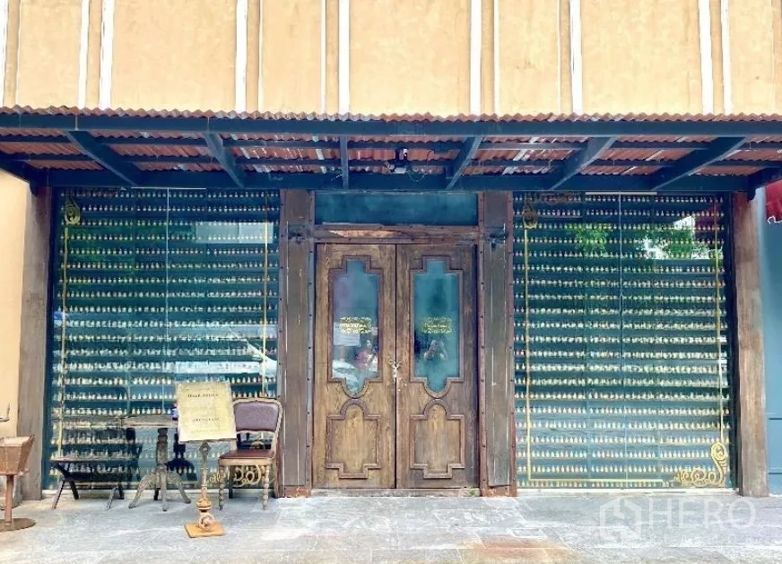 Retail Space for rent in Watthana, Bangkok - Rustic retail storefront with wooden double doors, full-height glass displays and a metal awning.