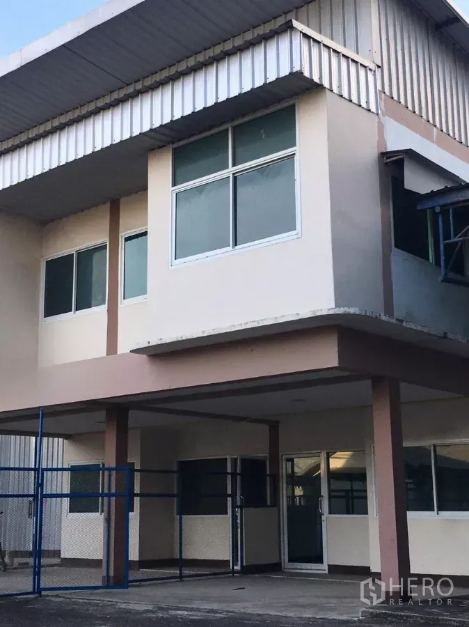 Warehouse for rent in Bueng Kum, Bangkok - Two-storey warehouse facade with large windows and a metal awning in the Nawamin area of Bueng Kum, Bangkok.
