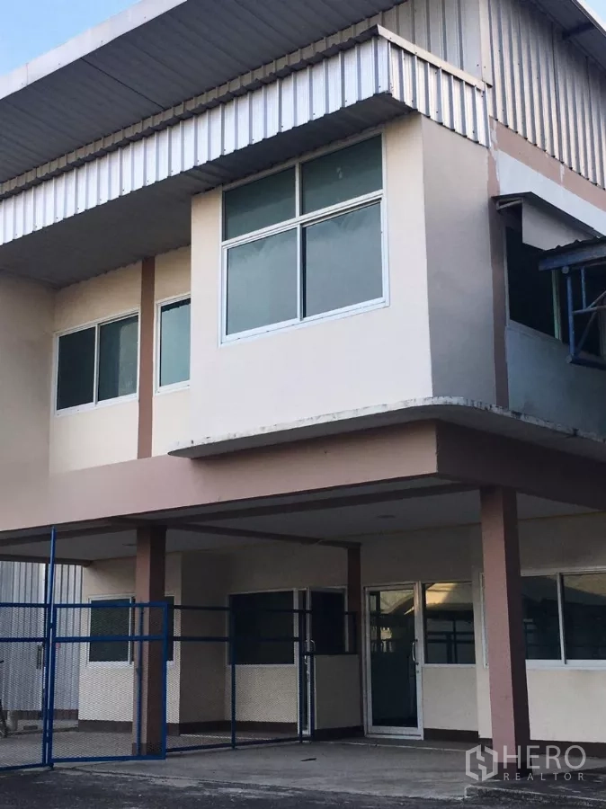 Warehouse for rent in Bueng Kum, Bangkok - Two-storey warehouse facade with large windows and a metal awning in the Nawamin area of Bueng Kum, Bangkok.
