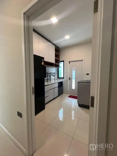 Detached House for rent or sale - Modern galley kitchen with white cabinetry and side door.