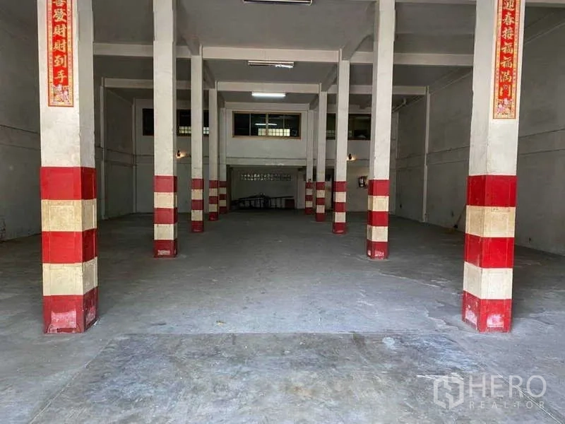 Warehouse for rent in Phasi Charoen, Bangkok - Open-plan warehouse interior with column grid, concrete floor and ceiling lights.