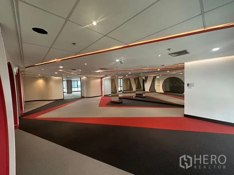 Office Space for rent in Khlong Toei, Bangkok - Spacious reception or lounge area with red and gray patterned carpet and linear ceiling lighting.