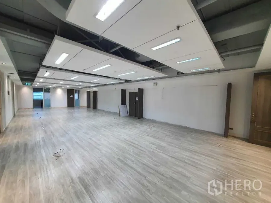 Office Space for rent in Watthana, Bangkok - Open-plan workspace with floating acoustic ceiling panels and vinyl floors.