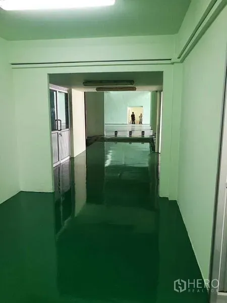 Factory for rent in Mueang Samut Sakhon, Samut Sakhon - Long internal passage leading to the production area with epoxy floor and strip lights.