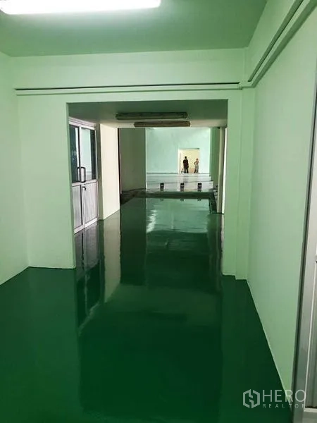 Factory for rent in Mueang Samut Sakhon, Samut Sakhon - Long internal passage leading to the production area with epoxy floor and strip lights.