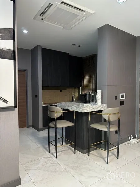 Detached House for rent in Phra Khanong, Bangkok - Compact kitchen corner with marble breakfast bar and two stools.