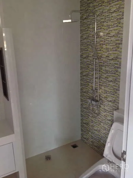 Detached House for rent in Lat Phrao, Bangkok - Minimalist bathroom with a walk-in shower and mosaic feature wall.