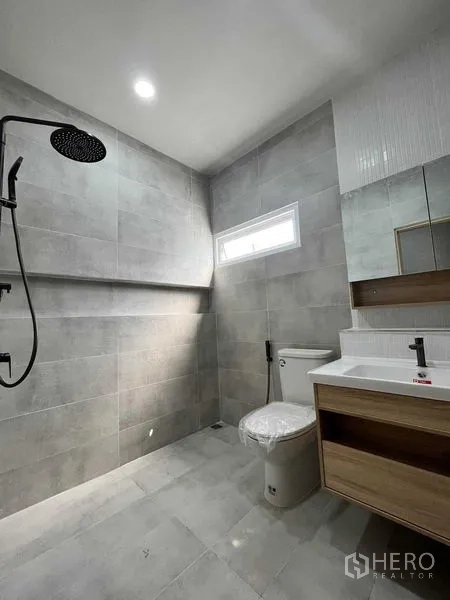 Townhouse for sale in Phra Khanong, Bangkok - Modern gray-tiled bathroom featuring a rain shower, vanity and toilet.