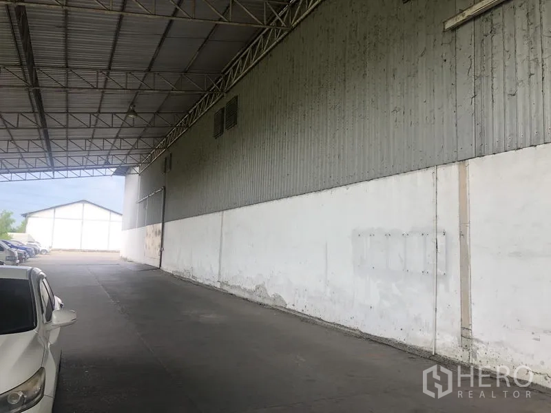 Warehouse for rent in Bang Pa-in, Phra Nakhon Si Ayutthaya - Long canopy along the warehouse wall creating shaded loading and parking space.