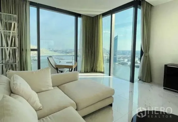 公寓 出租或出售在Bangkok - 转角起居室，贵妃沙发与全景玻璃俯瞰河景。