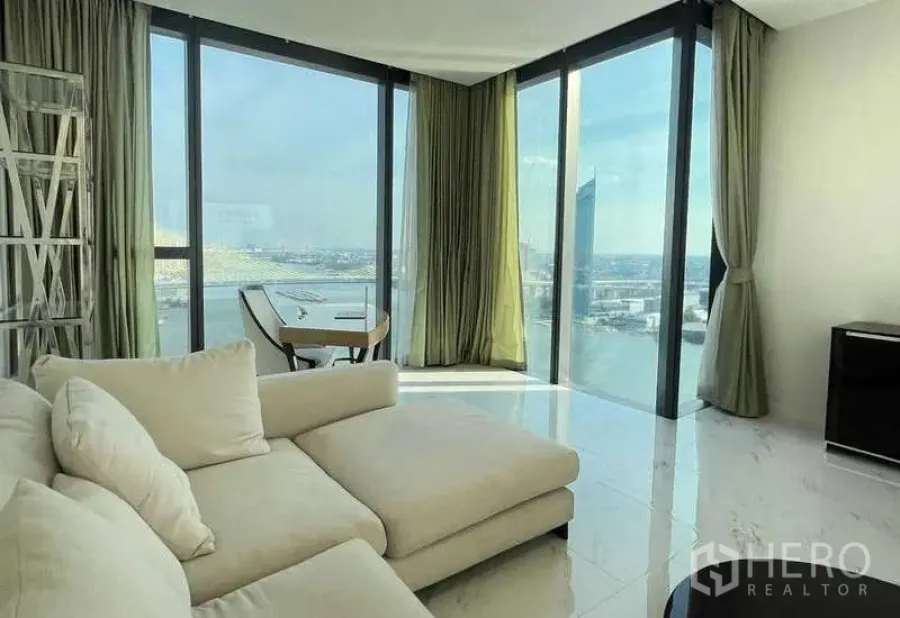 公寓 出租或出售在Bangkok - 转角起居室，贵妃沙发与全景玻璃俯瞰河景。