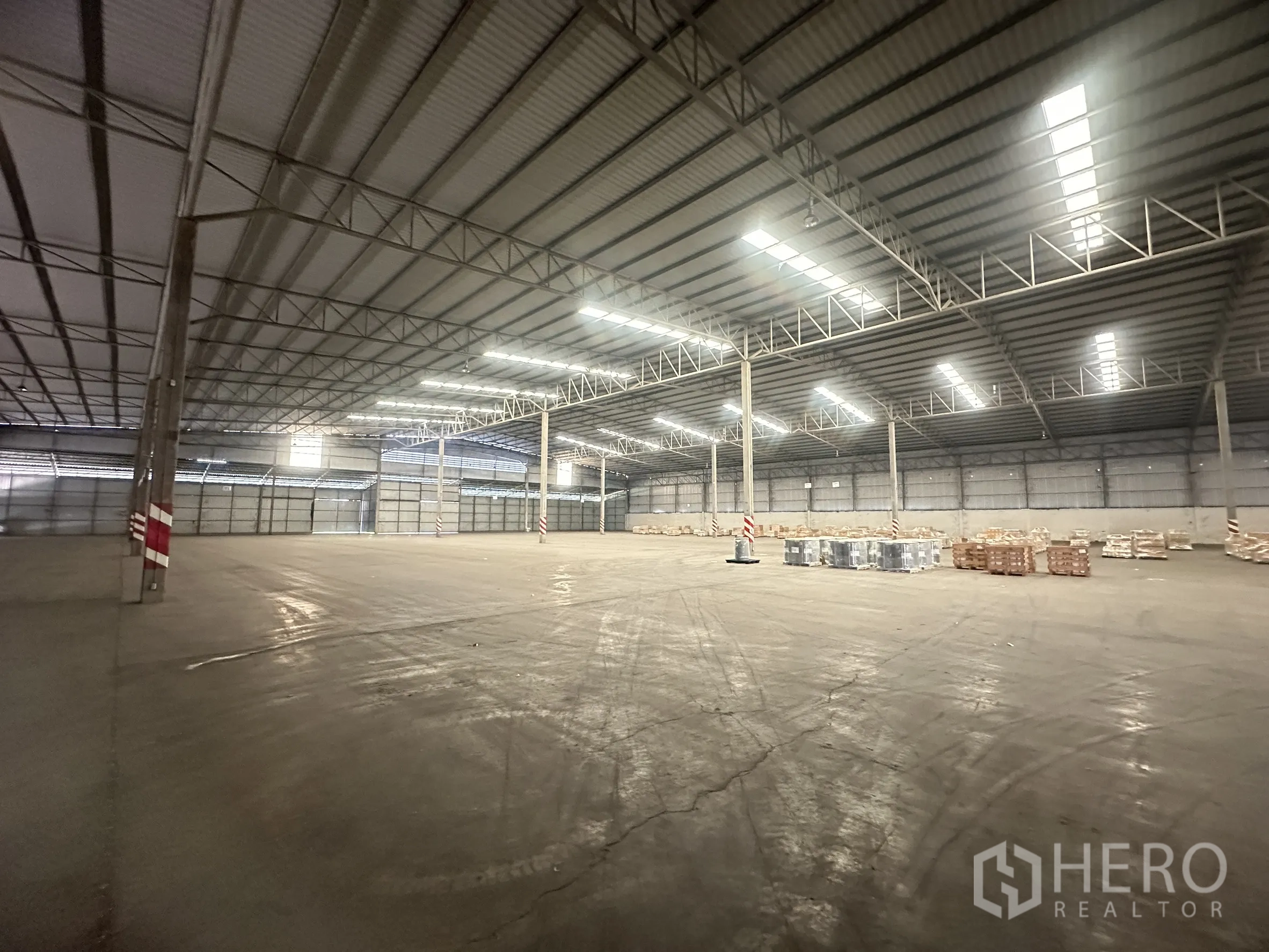 Warehouse for rent in Bang Pa-in, Phra Nakhon Si Ayutthaya - Corner angle showing clear floor plate, columns, and closed roller shutter doors.
