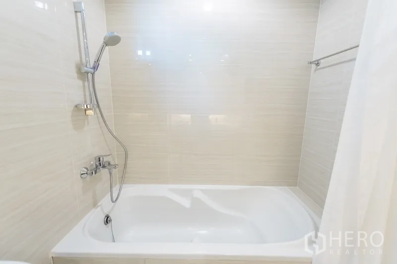 อพาร์ทเมนท์ ให้เช่าในYan Nawa, Bangkok - ห้องน้ำพร้อมอ่างอาบน้ำและฝักบัวมือถือ ผนังกระเบื้องโทนอ่อน