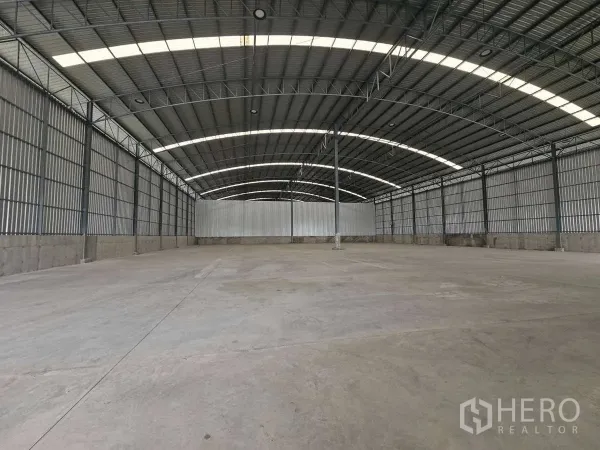 Warehouse for rent in Lam Luk Ka, Pathum Thani - Expansive warehouse interior with about 8 m clear height and smooth concrete floor.