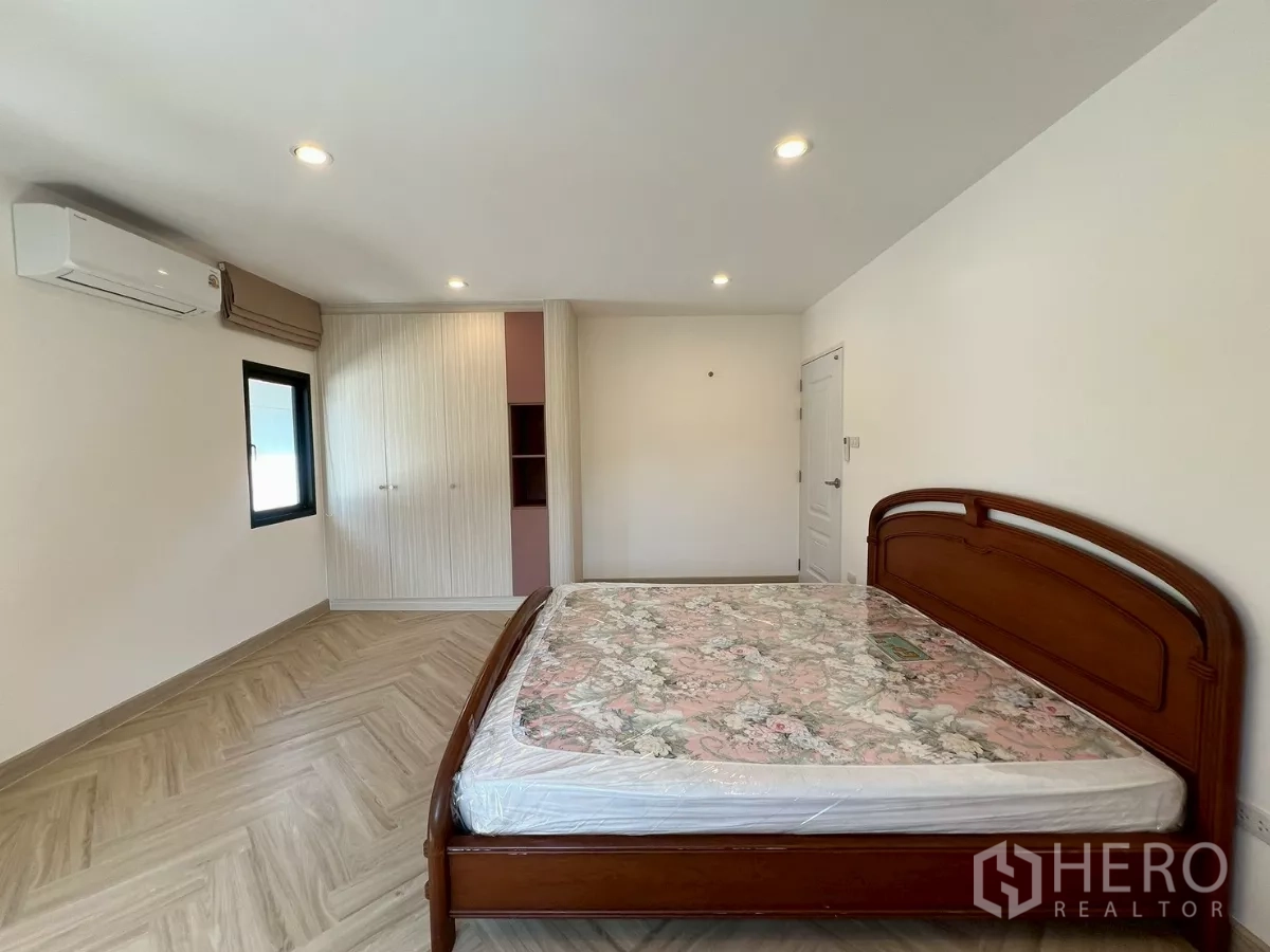 独立式住宅 出租在Suan Luang, Bangkok - 第二卧室另一角度，带嵌入式衣柜与柔和灯光。