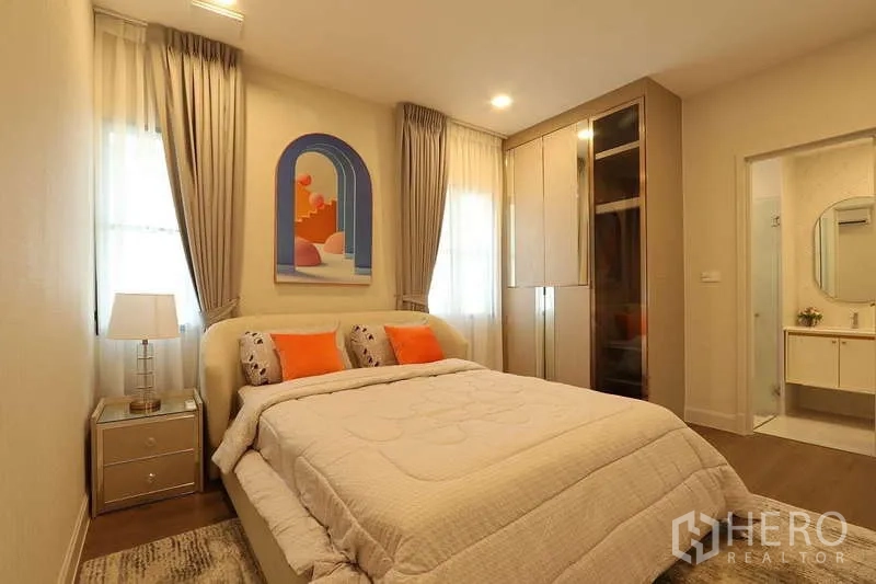 Detached House for rent in Saphan Sung, Bangkok - Guest bedroom with built-in wardrobe, warm lighting and entrance to an ensuite bathroom.