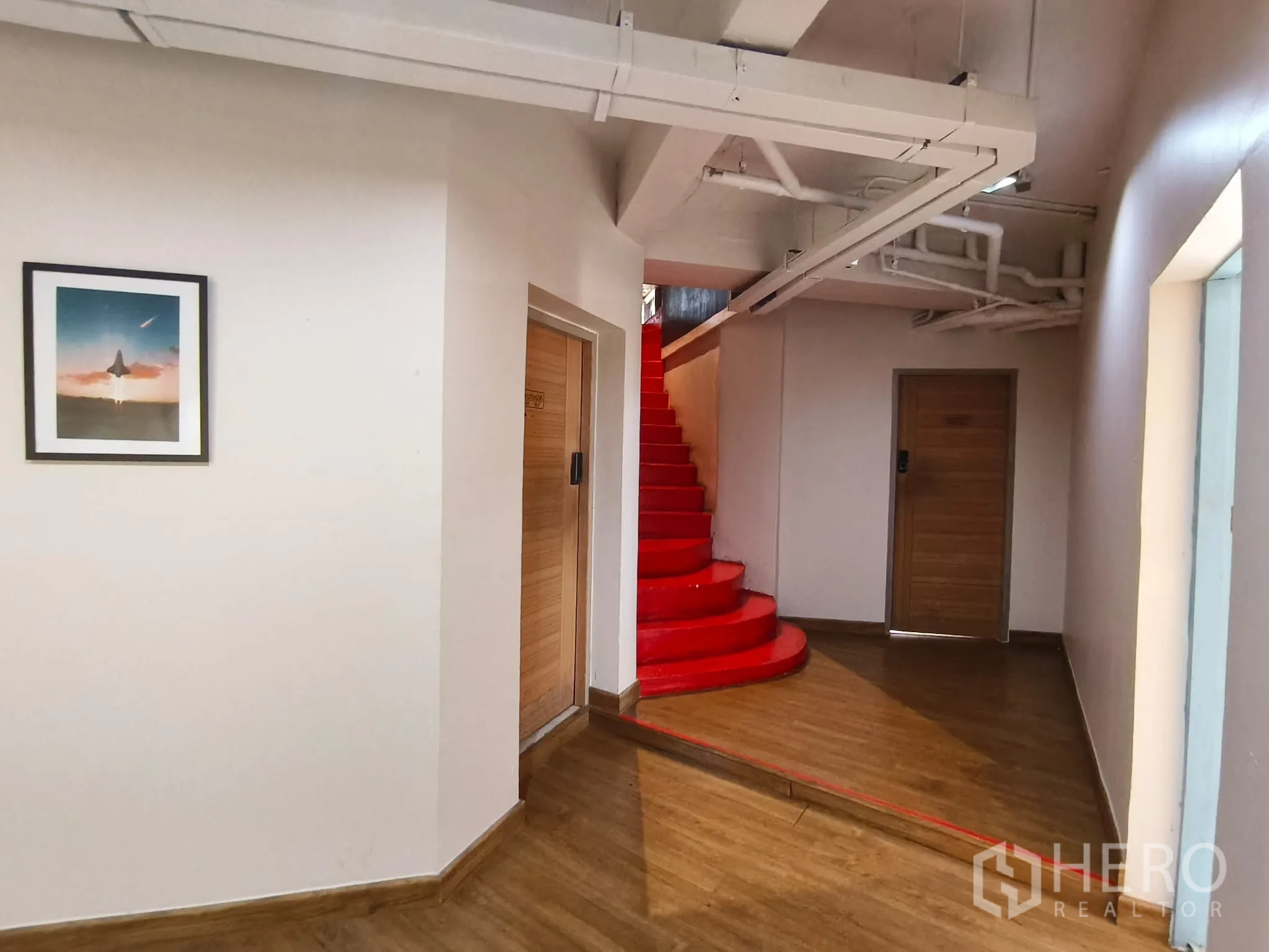 店屋 for rent in Watthana, Bangkok - 走廊内设醒目的红色旋转楼梯与木门。