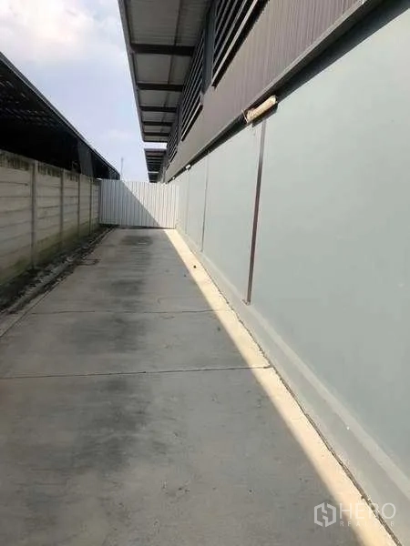 คลังสินค้า ให้เช่าในBang Phli, Samut Prakan - ทางเดินข้างอาคารพื้นคอนกรีตและกำแพงรั้วตลอดแนวโกดัง