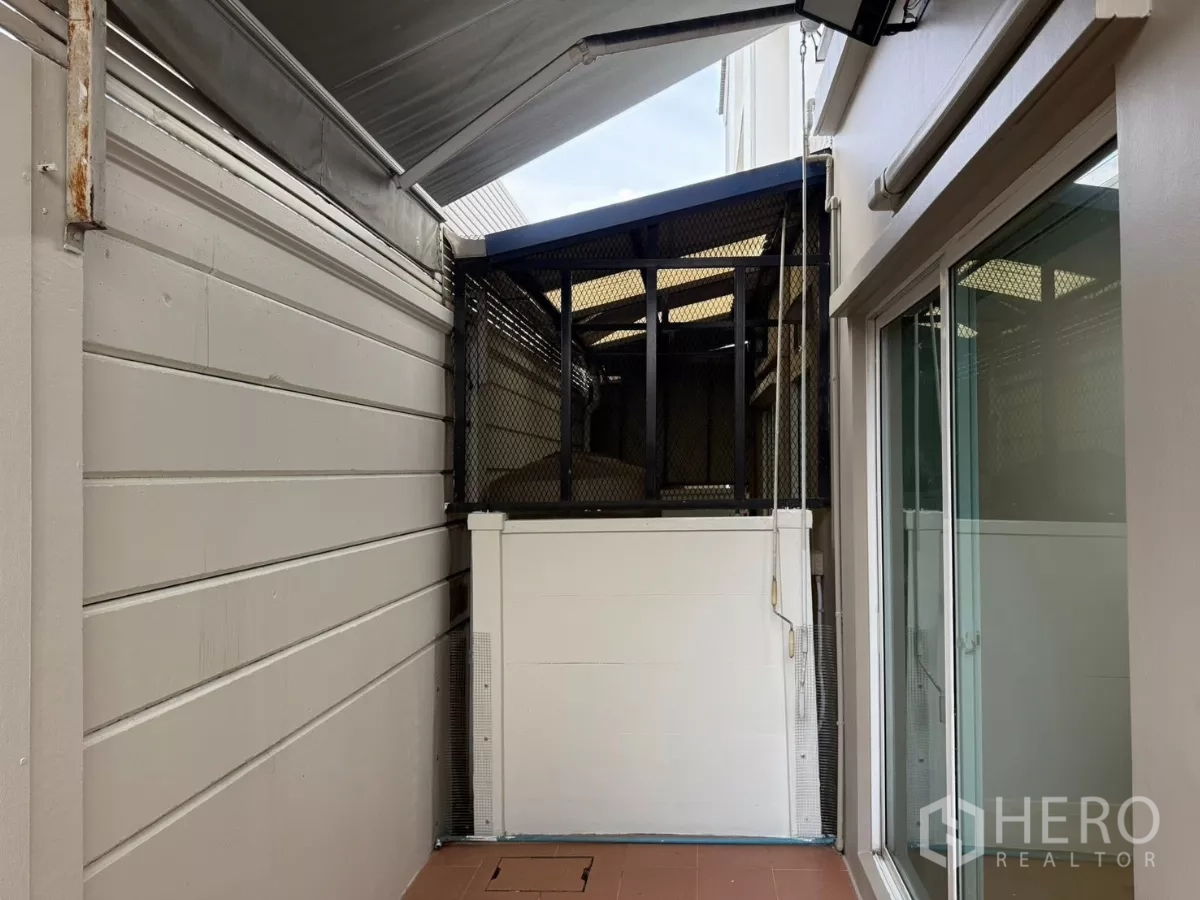 Townhouse for rent in Suan Luang, Bangkok - Narrow covered patio at the back of the townhouse with awning and screen.