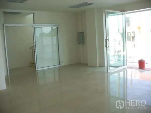 Factory for rent or sale in Samut Prakan - Ground-floor office area with glass partitions, sliding doors, and polished tile flooring at the factory entrance.