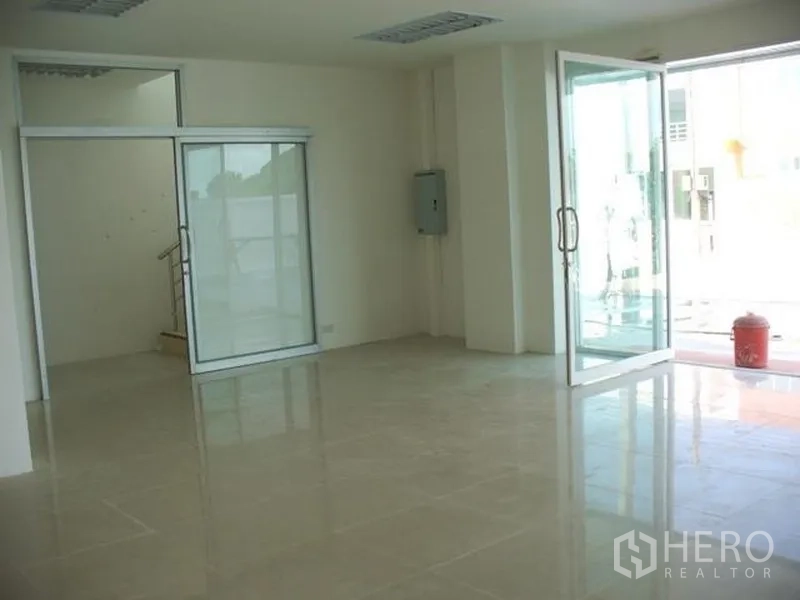 Factory for rent or sale in Samut Prakan - Ground-floor office area with glass partitions, sliding doors, and polished tile flooring at the factory entrance.