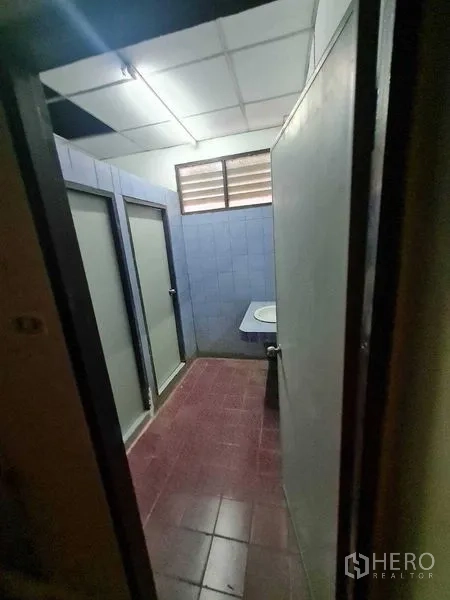 Warehouse for rent in Bang Yai, Nonthaburi - Restroom with two stalls, blue wall tiles and a single sink.