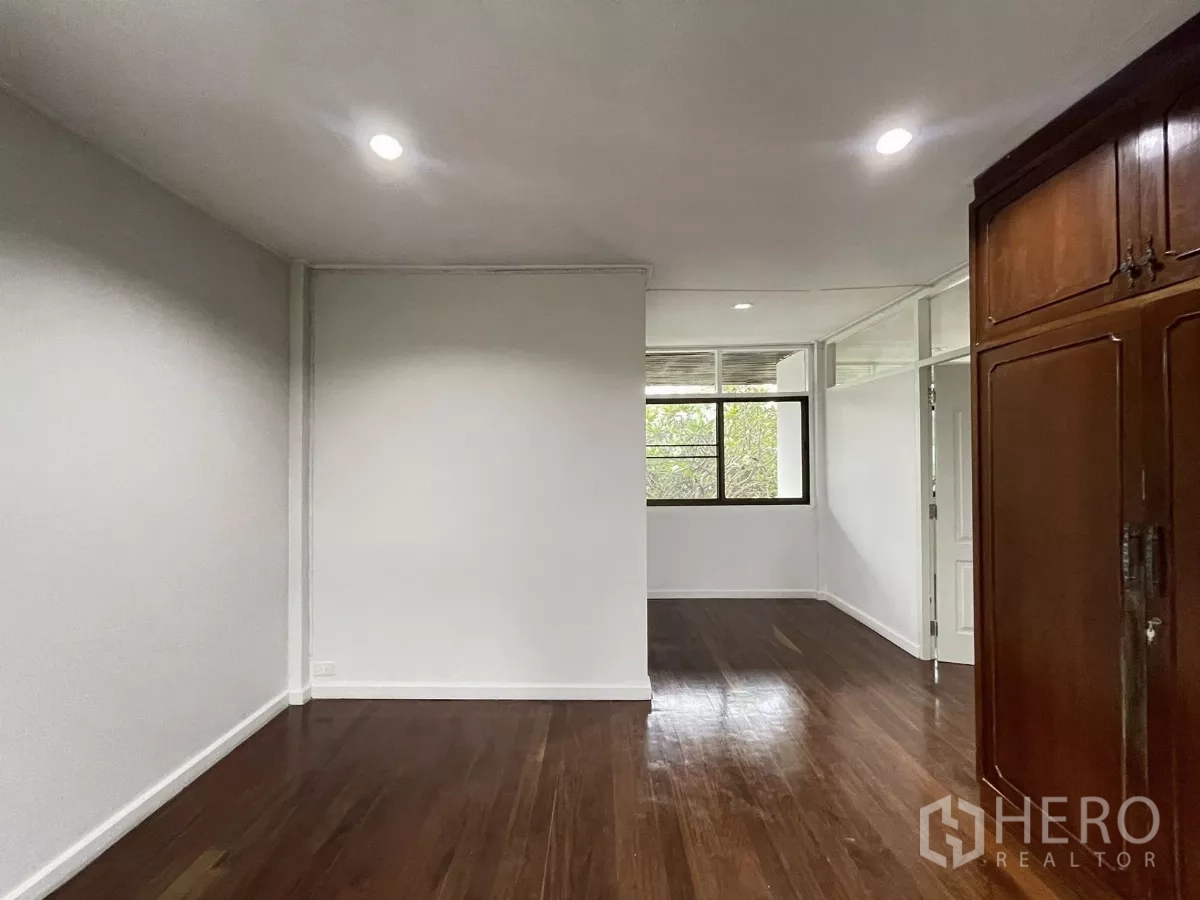 Home Office for rent in Din Daeng, Bangkok - Connected rooms with polished wood floors and additional storage cabinetry.