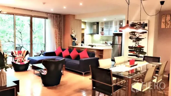 Condominium for rent in Bang Rak, Bangkok - Open-plan living and dining area with glass table, pendant lights, modern kitchen and balcony greenery view.