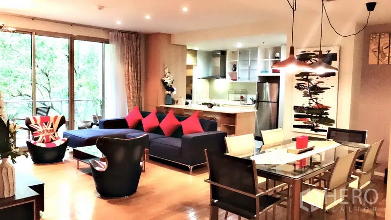 Condominium for rent in Bang Rak, Bangkok - Open-plan living and dining area with glass table, pendant lights, modern kitchen and balcony greenery view.