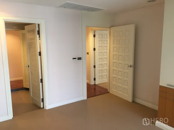 公寓 出租在Pathum Wan, Bangkok - 走廊明亮，带多扇方格门与百叶衣柜，位于巴吞旺区公寓内。