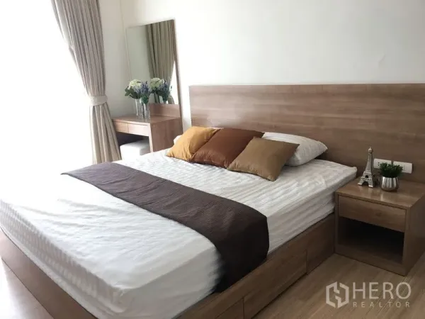 公寓 出租在Khlong Toei, Bangkok - 主卧采光充足，木质床、床头柜与梳妆台，浅色窗帘。