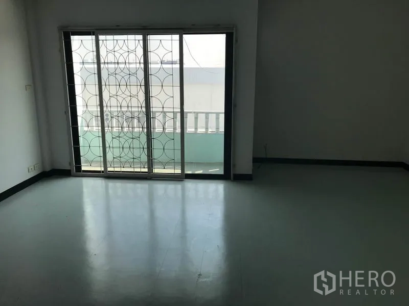 Office Space for rent in Khlong Toei, Bangkok - Room with balcony access through sliding doors and decorative metal grille.