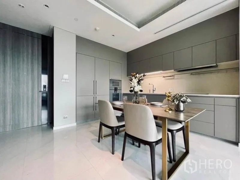 公寓 出租在Pathum Wan, Bangkok - 明亮用餐区，线性橱柜带底部照明与嵌入式烤箱。