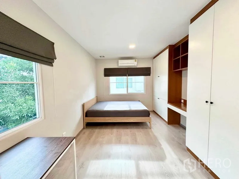 独立式住宅 出租或出售在Prawet, Bangkok - 卧室配双人床、内置衣柜、书桌、空调与窗户。