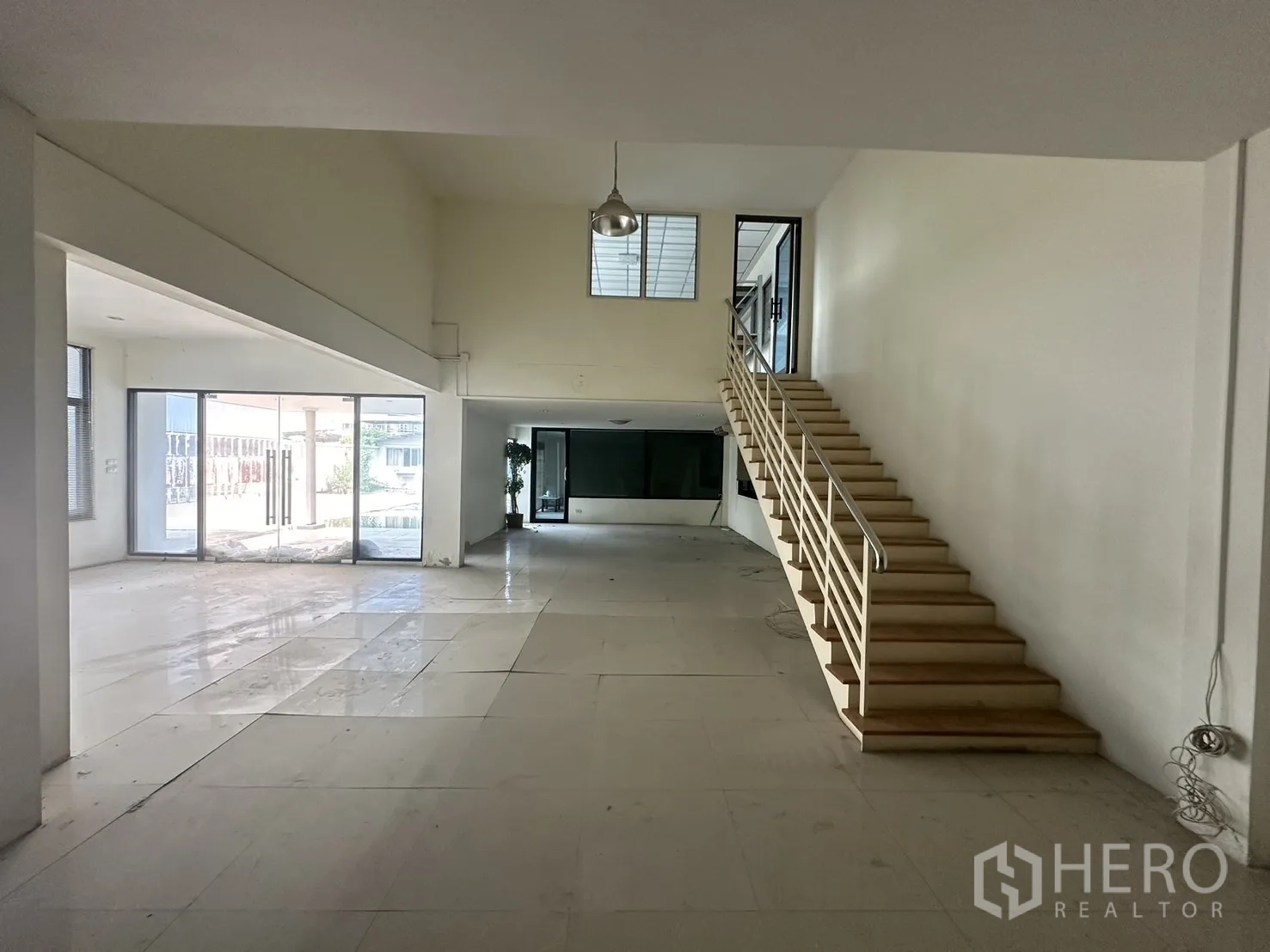 Factory for rent or sale in Prawet, Bangkok - Bright office lobby with tiled floors, staircase and full-height glass doors.