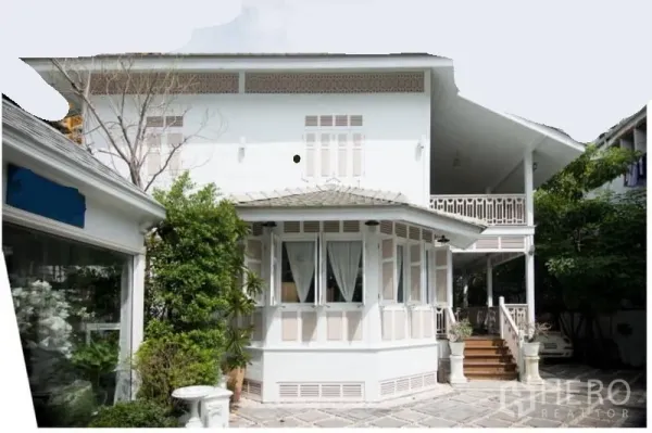 บ้าน ให้เช่าในBang Rak, Bangkok - ด้านหน้าบ้านสไตล์โคโลเนียลสีขาว มีหน้าต่างมุมและเฉลียงข้าง