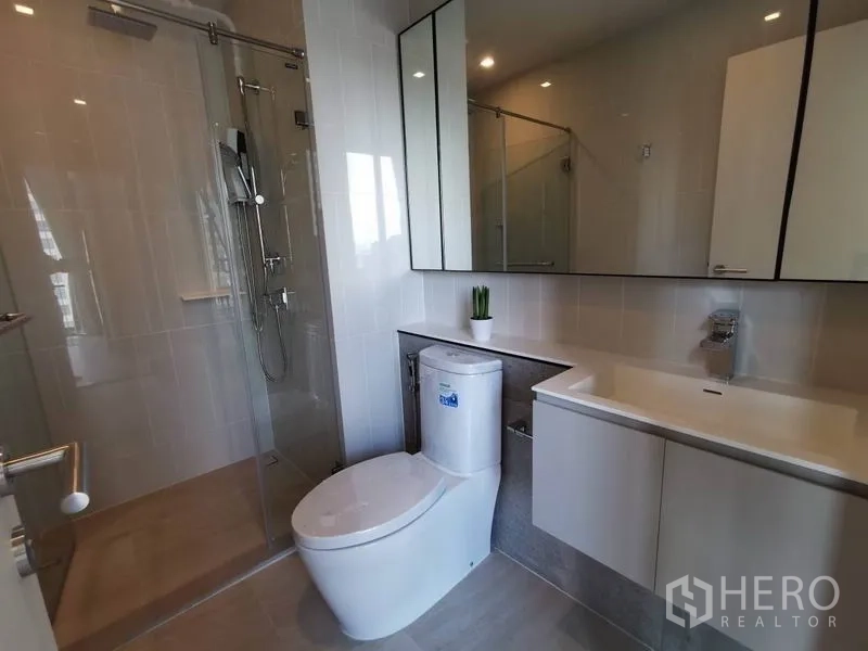 公寓 出租在Phaya Thai, Bangkok - 现代浴室，玻璃淋浴间、长台面洗手盆与镜柜。